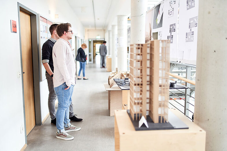 Two people look at exhibits at the exhibition/graduation ceremony at the Faculty of Architecture