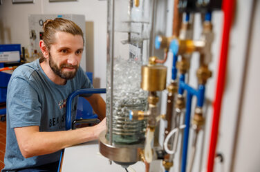 Foto von einem im Labor für Energietechnik & Wärmeübertragung, der einen Versuchsaufbau betrachtet.