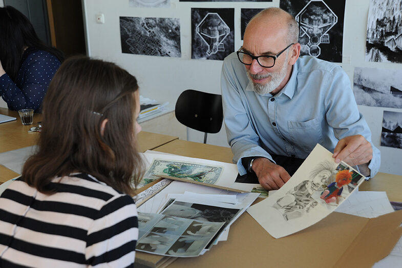 A person from the Faculty of Architecture shows a drawing to a visitor at the Open Day