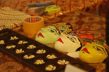Colorful masks and a traditional board game on the table at the Indonesia culture stand