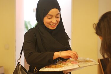 A student holding a bowl of food.