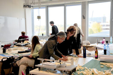 Kreative Gruppenarbeit in einem Hochschulatelier mit Architektur- oder Designprojekten.