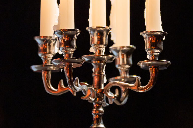 Foto von fünf brennenden Kerzen in einem Kerzenständer.