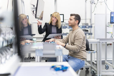 A professor explains something to a student about the demonstration product in the lean lab.