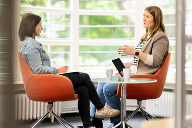 Zwei Personen sitzen sich in einem Beratungsgespräch gegenüber.