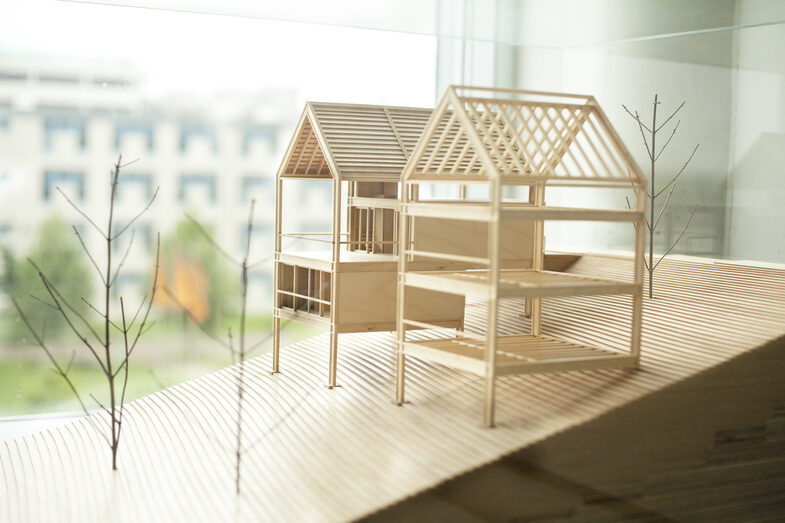 Photo of an architectural model of two wooden houses.