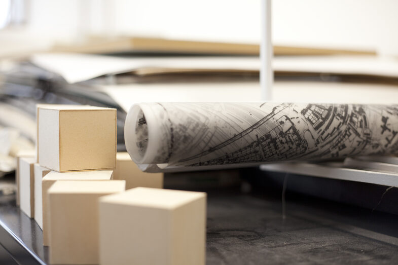 Close-up shelf with building plans and model cubes in the Faculty of Architecture