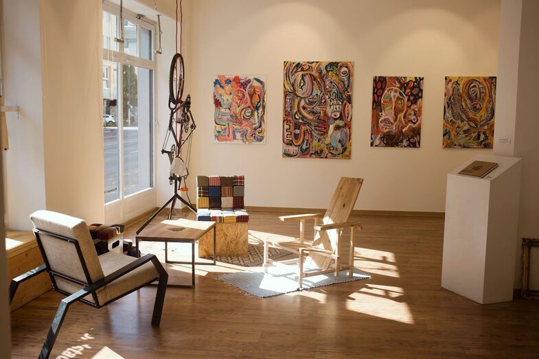 Interior view of the Nordstadtgalerie: a room with large windows containing artistic furniture and sculptures and painted pictures