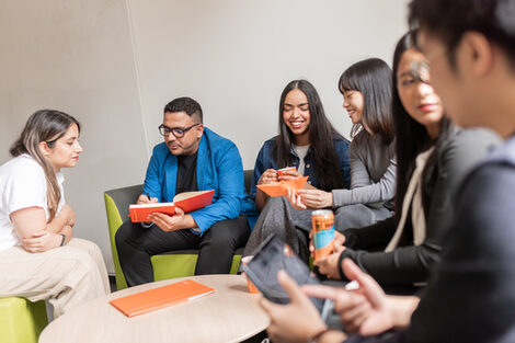 Gruppe internationaler Studierender sitzt in einer Sitzecke und unterhält sich.