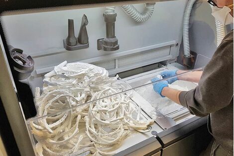 Photo of a person processing the results of a 3D print.