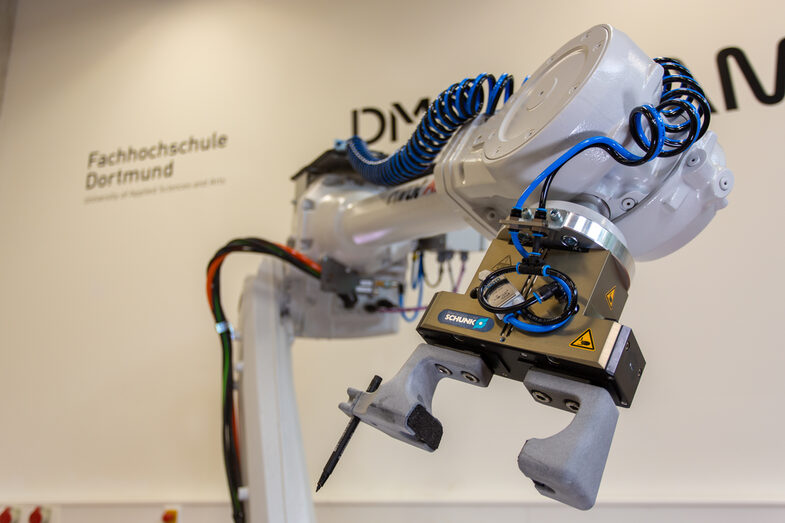 ABB robot with Schunk gripper, detailed view of gripper with pin with FH logo, landscape format