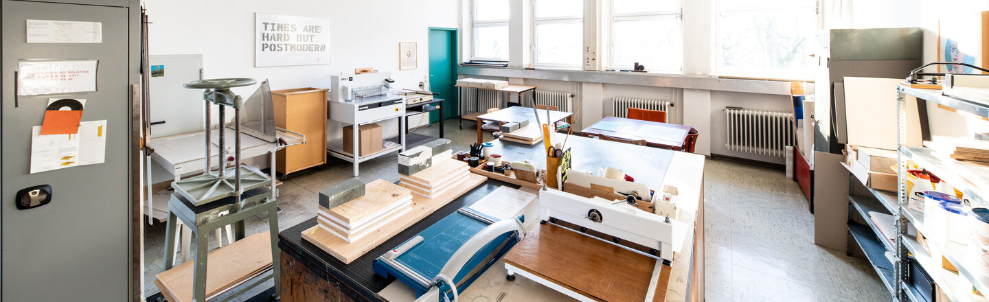 Photograph of the paper workshop. In addition to cupboards, shelves and tables, there is a lot of equipment here that is needed for paper processing/bookbinding.