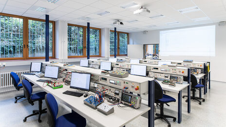 Photograph of the electronics and automation laboratory. Rows of tables with devices and computers.