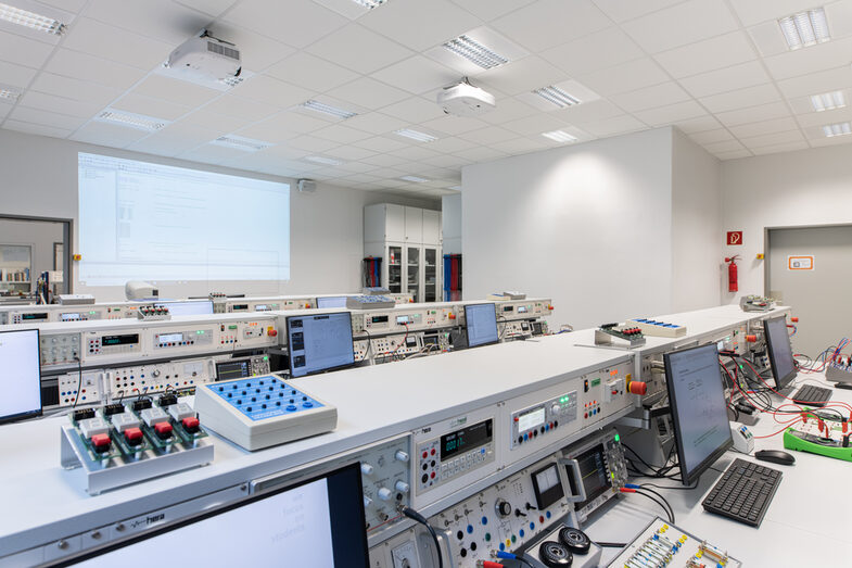 Photograph of the electronics and automation laboratory. Rows of tables with devices and computers.