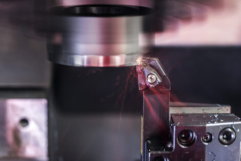 Close-up of a milling machine in operation. A few sparks are flying.