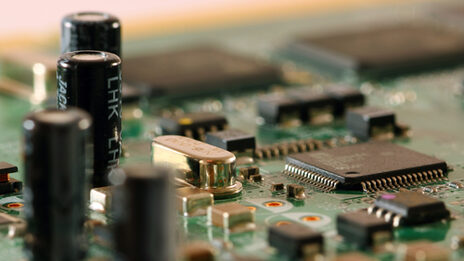 Photo of a computer board with microcontroller and capacitors.