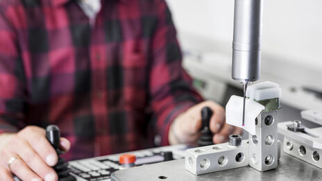 Photo of a person working with a 3D CNC coordinate measuring machine.