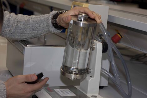 Photo of a viscometer being worked on by a person.