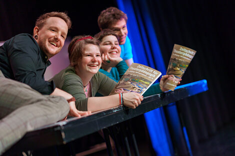 Foto von lachenden Schauspieler*innen bei einer Probe im Theaterlabor.