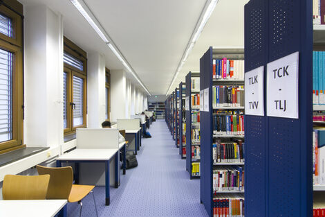 Photo of rows of bookshelves and individual desks in the library__Photo of library book shelves and desks
