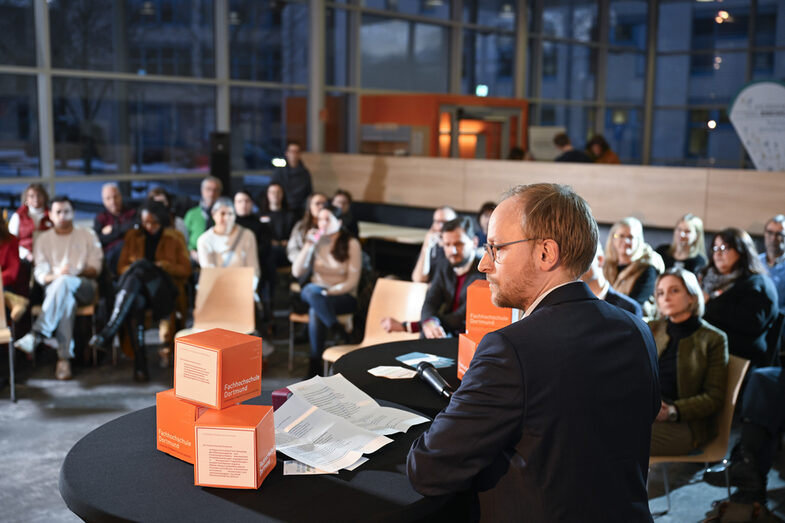 Prof. Dr. Franz Vogler steht an einem Tisch und blickt ins Publikum