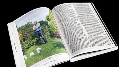 An open book, on one side a large photo of a man reading in a garden, on the other side text.