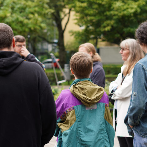 Sechs Personen stehen in einem Park.