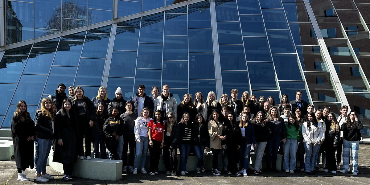 Gruppenfoto aller TeilnehmerInnen und mitwirkenden DozentInnen beider Partnerhochschulen (insgesamt ca. 50 Personen) vor dem Campus Hogeschoollaan 1 in Breda (NL) der Avans University of Applied Sciences.