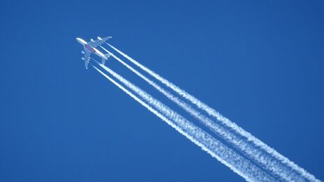 Am Himmel sind ein Flugzeug und dessen Kondensstreifen zu sehen.