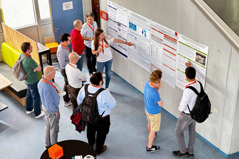 The photo shows several participants of the ENBIS Spring Meeting looking at the posters on display and discussing them.