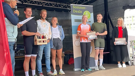 Several people stand next to each other on a stage.