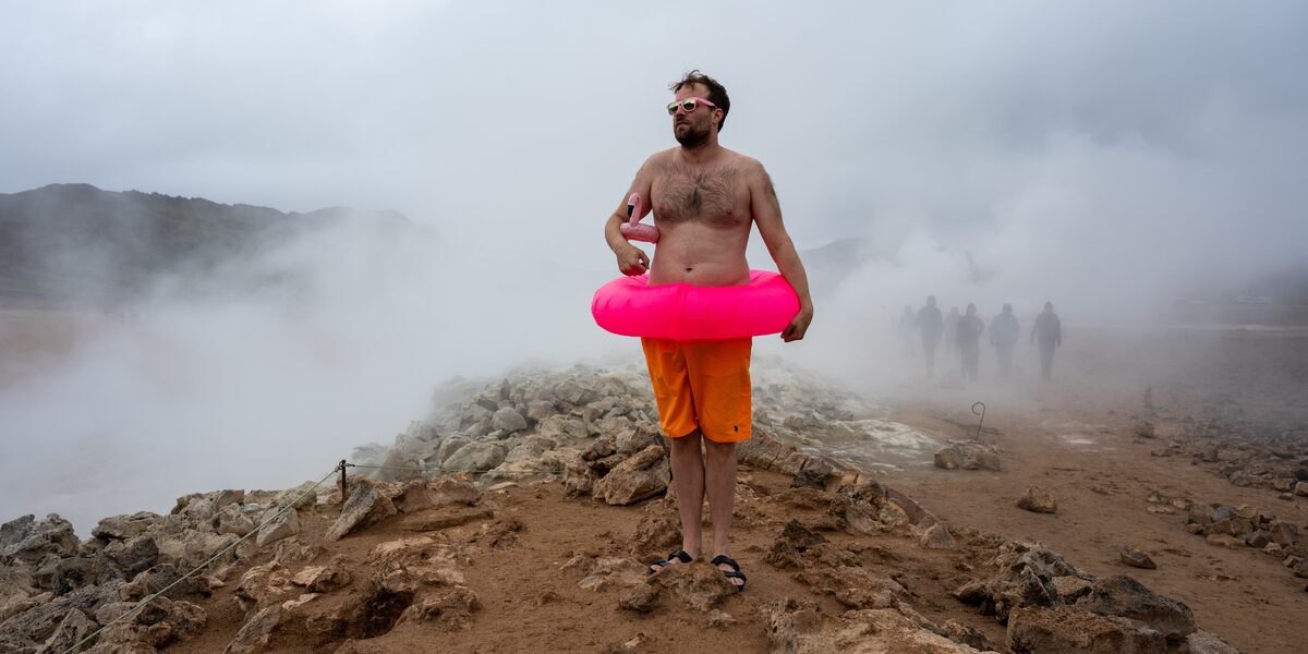 The picture shows a member of the MSG collective in a natural pool in Iceland. The picture is staged, among other things with a pink swimming tire