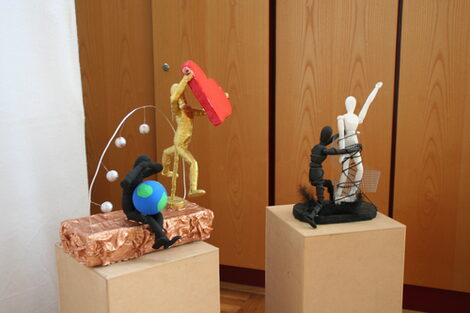 Zwei sog. Nana-Skulpturen auf jeweils einem Podest bei einer Ausstellung