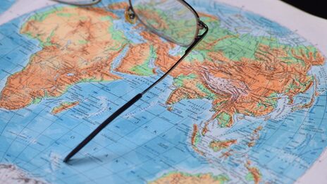 A world map with a pair of glasses on it.