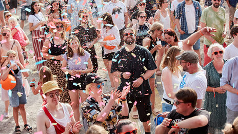 People in front of the stage in a shower of confetti.