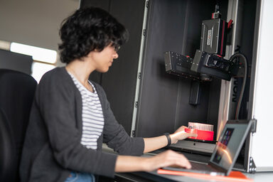 A female reader places a slide under a hyperspectral camera