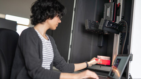 A female reader places a slide under a hyperspectral camera