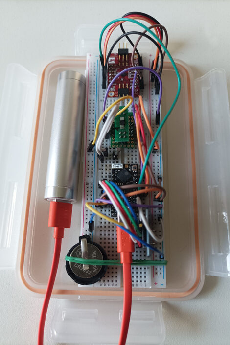 In einer Plastikschale liegt ein elektronischer Bausatz mit mehreren Kabeln.