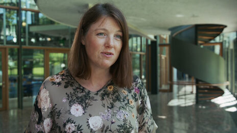 A female read person in an interview situation in front of the camera.