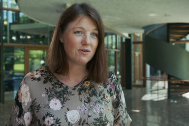 A female read person in an interview situation in front of the camera.