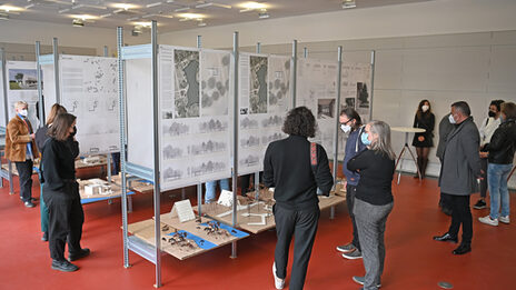 People look at models and architectural drawings for the "Parking garage, parking space, parking tree" project in the Baukunstarchiv NRW.