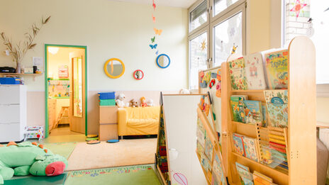 A room with toys and books for small children, as is usual in a day care center.