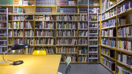 Photo of the library reading room with book shelves, desks, reading lamps and chairs__Photo of the library reading room with book shelves, desks, reading lamps and chairs