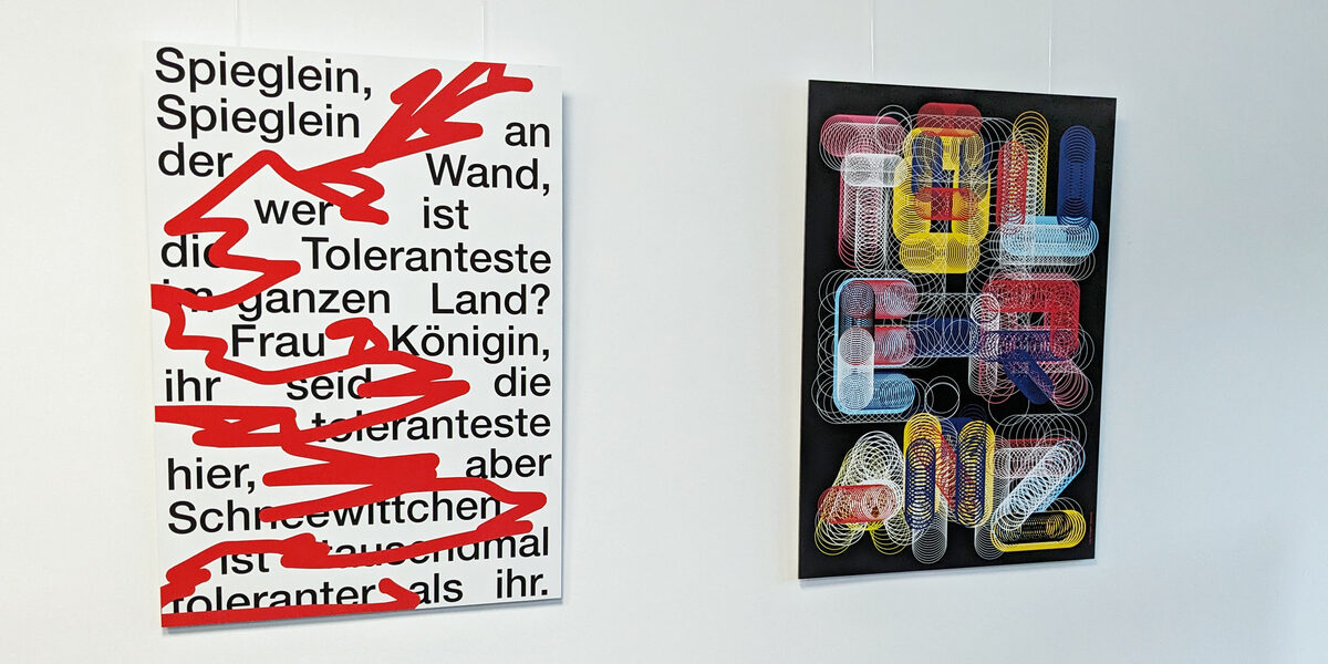 Two posters on the subject of tolerance hang on a white wall. One poster asks: "Mirror, mirror on the wall, who is the most tolerant in the whole country?"