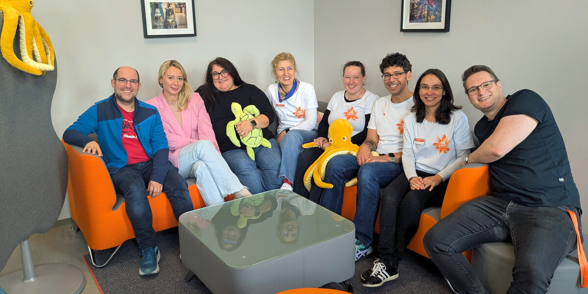 A group of people are sitting close together in the corner of a sofa.