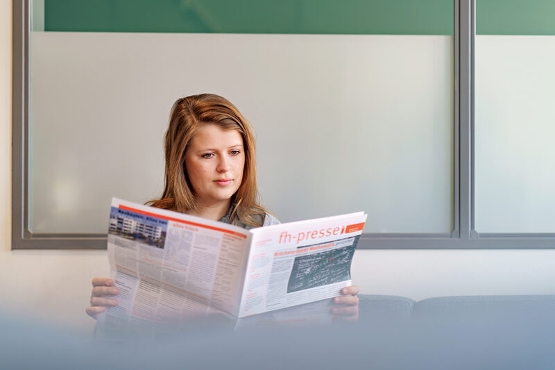 Foto einer Studentin, die in der FH-Presse liest.__A young woman reads the FH-Presse.