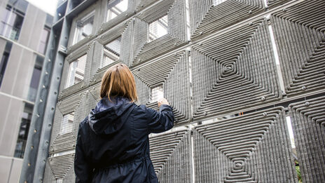 Close-up: A person stands in front of a robotically printed façade