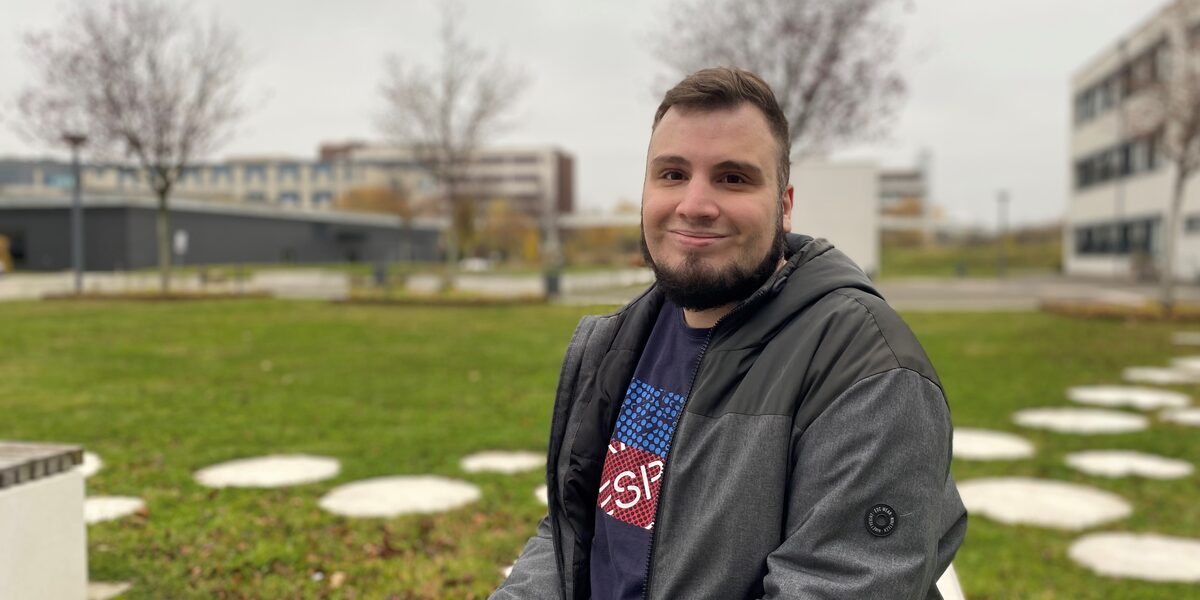 Porträtfoto, das Burak Üyüküler auf dem Campus der Fachhochschule Dortmund zeigt