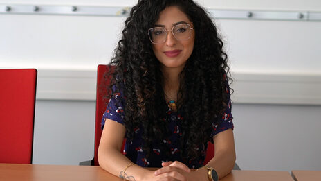 Portrait photo showing Sedra Dayoub sitting at a table
