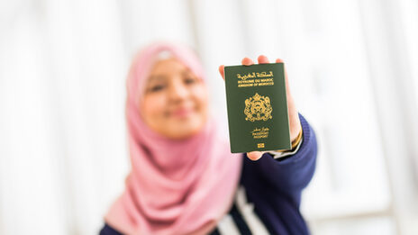 Photo of a student holding her Moroccan passport up to the camera.